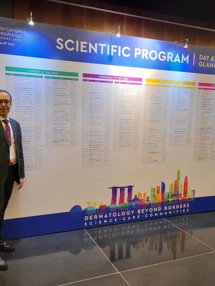 Standing before the scientific program at the 25th World Congress of Dermatology in Singapore. Continuous learning is non-negotiable in medicine; it allows me to bring the best global practices back to my patients.