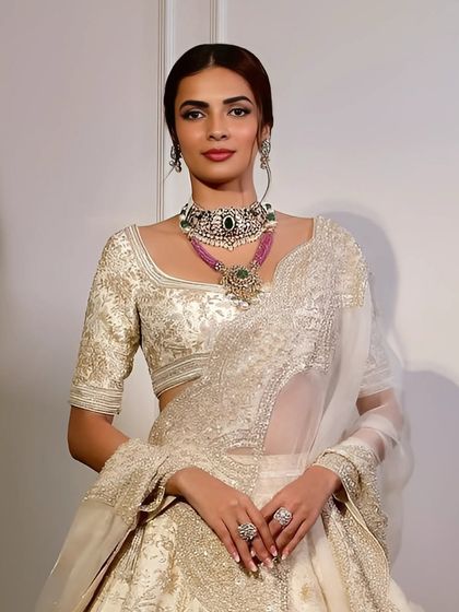 For the bride who believes more is magnificent. A double-stacked look featuring a handcrafted choker in emeralds, diamonds, and pearls, layered with a rose-pink necklace.