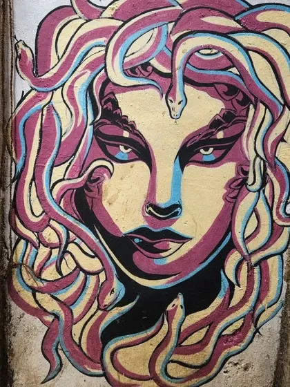 A striking mural of Medusa with colorful, snake-like hair. This piece brings a touch of Greek mythology to the streets of Mumbai, rendered in a bold, graphic style.