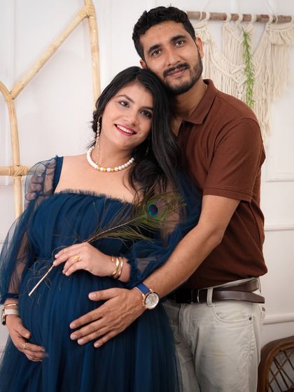 A sweet moment between the expecting couple. The peacock feather adds a unique and symbolic touch to this loving maternity portrait.
