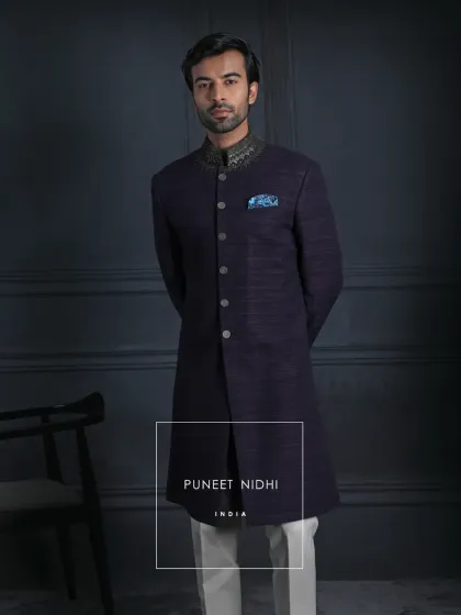 This deep wine handloom silk achkan is poetry in fabric. The antique metallic buttons mark tradition, and the embroidered neckline shines like crafted jewelry, bridging heritage with the soul of today.