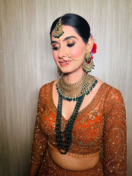 A downward glance showing the detailed eye makeup. The soft brown and gold tones on the lids are perfect for a traditional wedding look, adding depth without being overpowering.