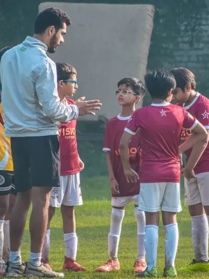 A coach gives instructions to his U10 team. We start building football IQ from the earliest age groups, teaching them the fundamentals of teamwork and positioning.