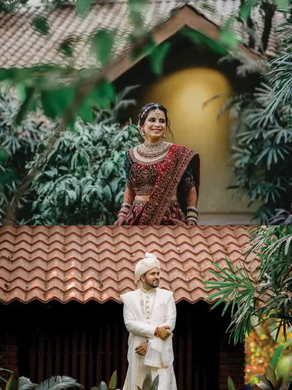 A creative composition showing the bride on a balcony above the groom. This shot plays with levels and perspective to create a unique and artistic wedding portrait.
