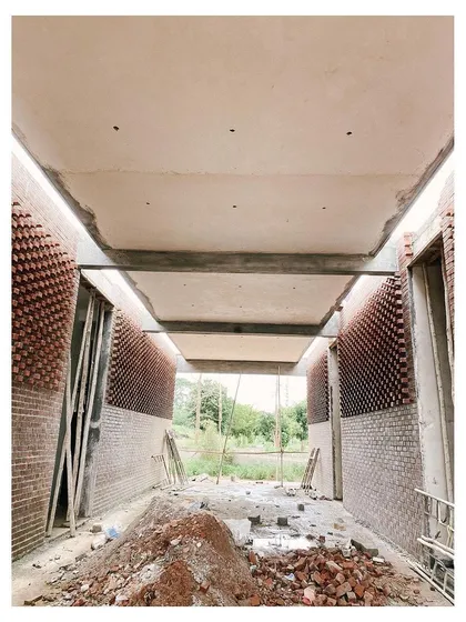 The unfinished corridor of the memorial, showing the exposed concrete ceiling and brick walls.