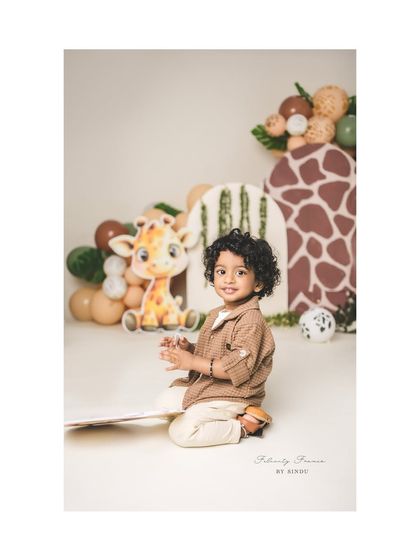 A candid moment of clapping and smiling during a safari-themed second birthday shoot.