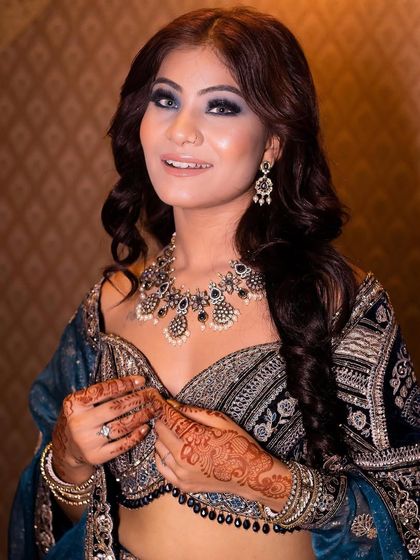 This midnight beauty look features a deep blue smokey eye and glossy nude lips. It is a glamorous and captivating style for an evening reception or cocktail party.