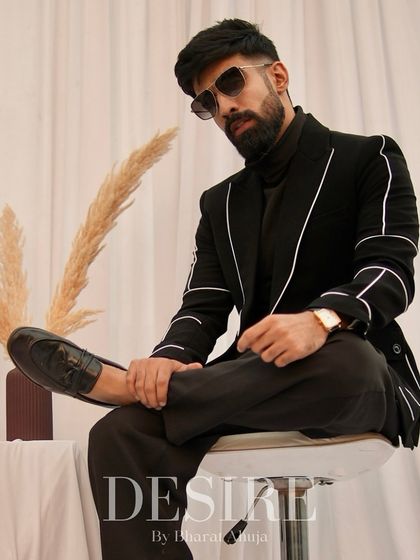 A confident pose in the black blazer with white piping. This piece is perfect for creating a sharp, modern look that is both timeless and versatile.