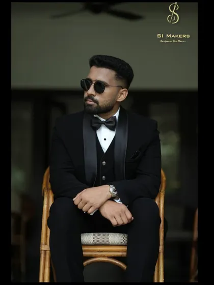 The classic black tuxedo, redefined. This bespoke three-piece suit is crafted from premium fabric, featuring satin lapels and a tailored fit that ensures a sharp, timeless look for any formal occasion.