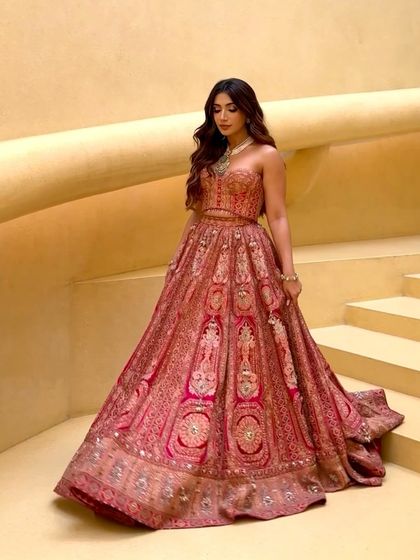 The full view of the corset lehenga on a grand staircase, highlighting its dramatic silhouette and regal appeal.