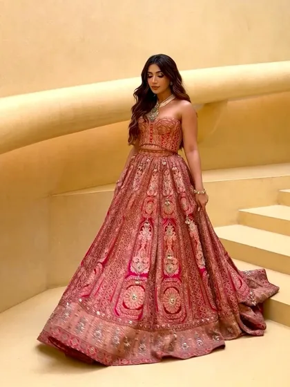 The full view of the corset lehenga on a grand staircase, highlighting its dramatic silhouette and regal appeal.