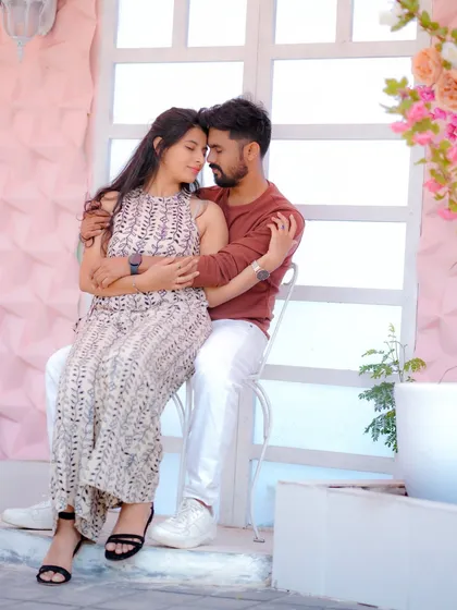 A tender moment against a romantic floral backdrop. The soft pink tones and the couple's gentle embrace create a dreamy and affectionate pre-wedding portrait.