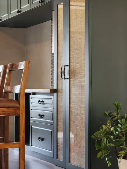A view into a study nook, featuring a dark-painted finish contrasted with natural wood and woven panels. This design shows how I use color and texture to define functional zones within a larger space, creating cozy, practical areas for work and life.