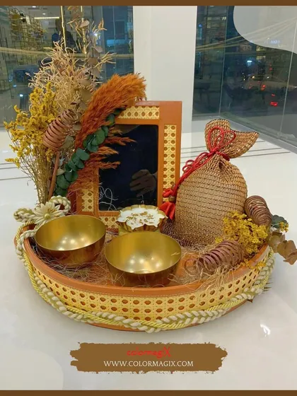 A rustic yet elegant tray hamper featuring woven details and brass bowls. It's adorned with dried flowers, making it a perfect piece of decor long after the treats are gone.