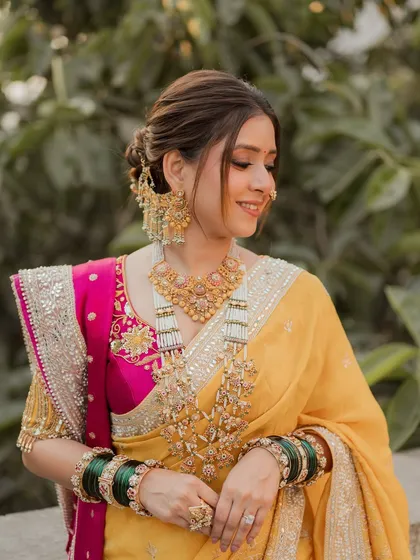 A radiant Maharashtrian bride in a stunning yellow and pink Nauvari saree. I created a soft, elegant updo to complement her traditional jewelry and nath, ensuring she felt comfortable and beautiful on her special day.