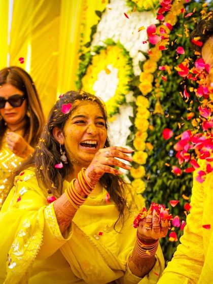 The bride playfully throws petals at the groom, capturing a moment of laughter and fun.