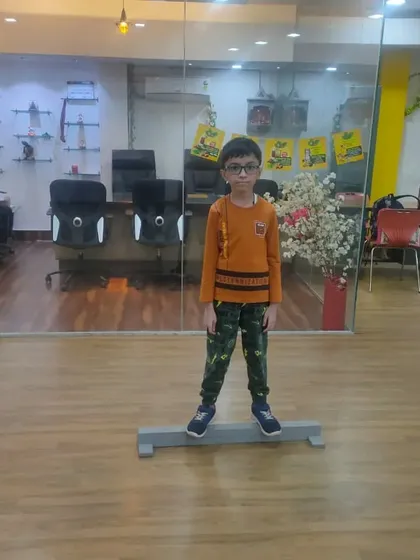 Training starts with the fundamentals. Here, a young student practices a balance exercise on a beam, a key drill we use to build core stability and a steady stance, which is crucial for accurate shooting.