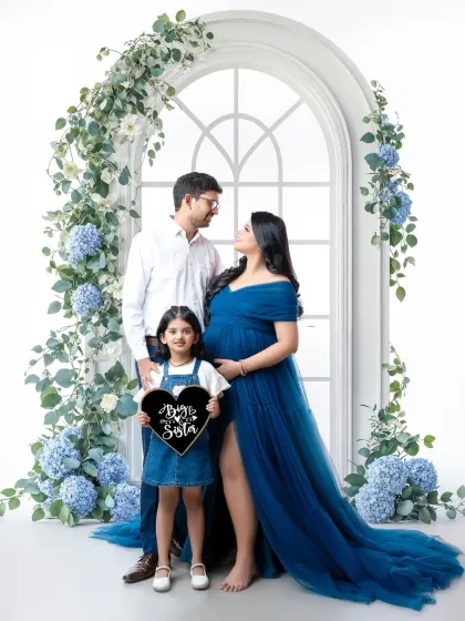 And then there were three. We love including the whole family in our maternity sessions. This portrait captures the sweet anticipation of a big sister meeting her new sibling, framed by a beautiful floral archway that symbolizes their growing family.