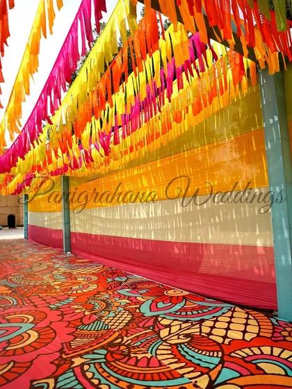 A long walkway covered in colorful streamers, creating a festive and immersive entrance for the carnival event.