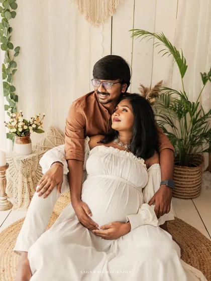 An expecting couple shares a quiet moment in a light-filled, boho-inspired setting. This image showcases the airy, relaxed, and earthy style of my lifestyle maternity sessions.