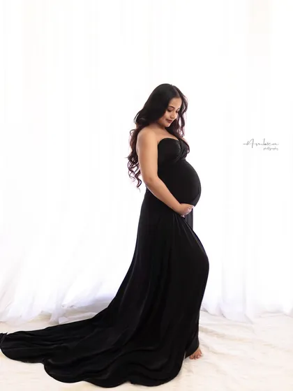A slight variation in pose, with the mother-to-be looking down at her bump. This simple gesture adds a layer of tenderness and connection to the elegant, modern portrait.