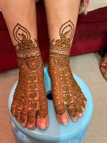 A beautiful foot design with a focus on lotus motifs, covering the entire foot in a dense and traditional pattern.