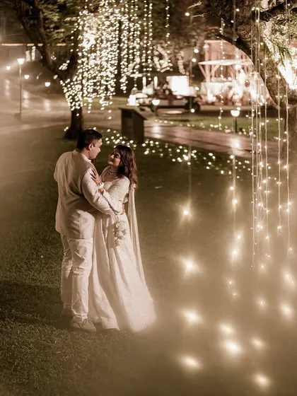 A fairytale moment. The couple shares a dance in a garden illuminated by thousands of cascading fairy lights, creating a dreamy and intensely romantic setting for their sangeet.