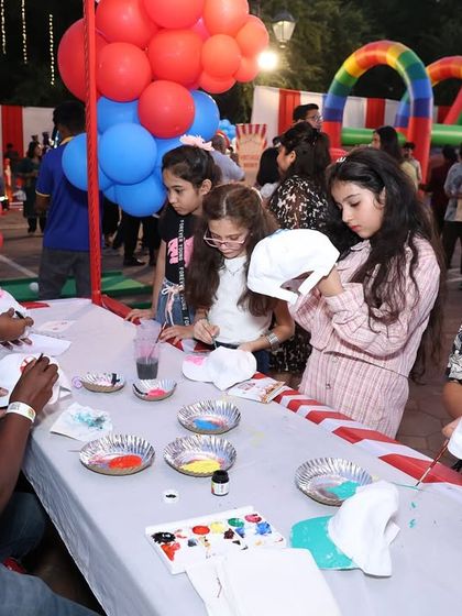 A cap painting stall at an outdoor carnival. This creative station allows kids to personalize their own caps, giving them a fun activity and a cool party favor.