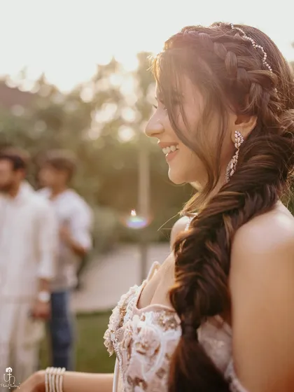 A close-up on that happy, sun-kissed glow. The side-swept fishtail braid and natural-looking makeup are perfect for a daytime wedding event.