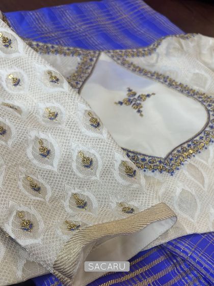 A detailed shot of the off-white georgette blouse, showing the delicate embroidery on the sleeves and around the back cutout.