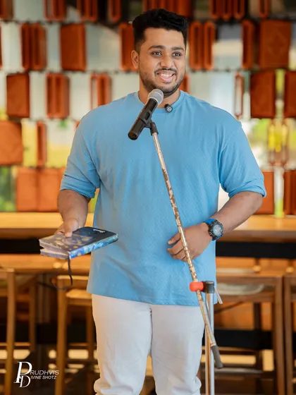 A poet holds his book during our Pride-themed open mic. The event was a testament to what community and pride sound like.