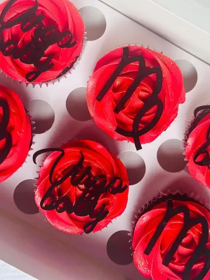 This image captures the deep red color of the buttercream and the precise, clean lines of the Virgo symbol toppers.