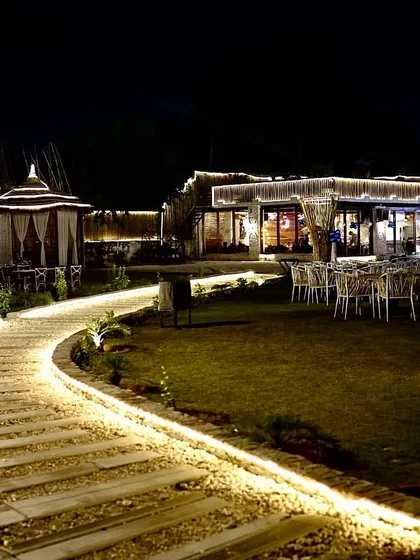A view of my venue at night, showcasing the different spaces available. From the lit pathways and lush lawns to the private cabanas and indoor hall, you can see how it all comes together to create a special ambiance.