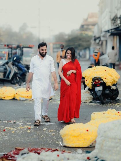 A wide shot showing the couple walking through the flower market, capturing the scale and atmosphere of the location.
