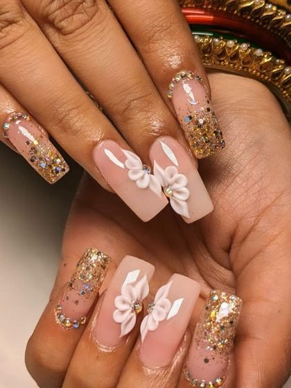 A truly showstopping bridal set. These long, square-shaped extensions feature gold glitter, 3D white flowers, and rhinestone-lined cuticles for maximum glamour.