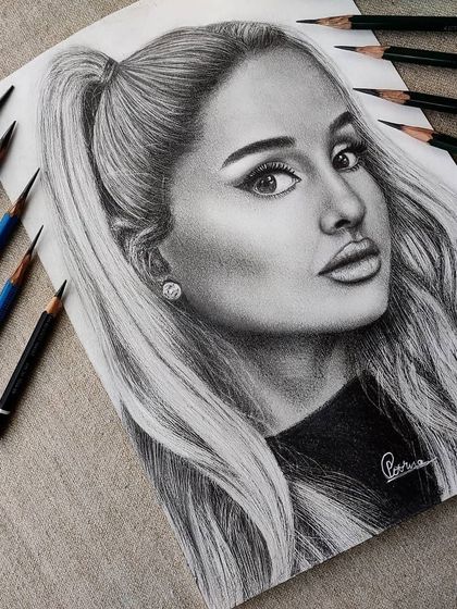 A different angle of the finished Ariana Grande portrait, with the pencils I used displayed alongside it.