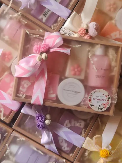 A close-up of the Women's Day hampers, beautifully wrapped with pink and purple ribbons and floral accents.
