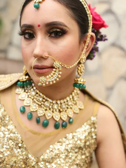 A close-up portrait of a bride with beautiful green bead jewelry. Her look is a mix of traditional and contemporary style.