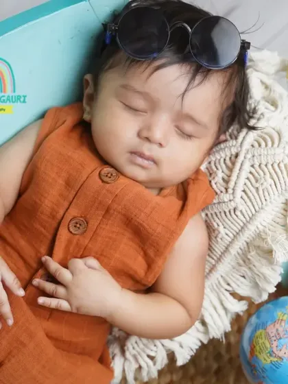 A close-up of a sleepy three-month-old, looking cool with his sunglasses. Even when they're napping, we can capture adorable shots.