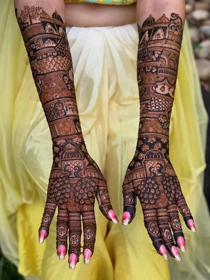 The full view of this stunning peacock-themed bridal mehendi, extending from fingertips to elbows.