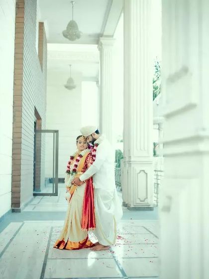 An artistically framed shot of a couple embracing in a white corridor, creating a clean, bright, and modern wedding portrait.