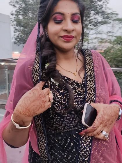 A close-up of the client's festive makeup, featuring a bold red lip and shimmery pink eyeshadow.