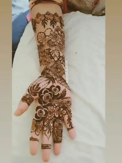 A stunning example of a full-arm design that combines bold floral work on the palm with a delicate, leafy vine that trails up the arm.