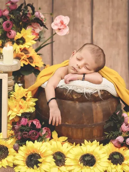 A slightly different pose, with the baby's arm draped over the side of the bucket. These small adjustments help capture the most relaxed and natural sleeping positions.