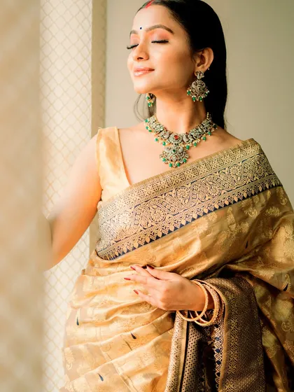 A soft and dreamy bridal inspiration look. The model wears a golden saree, and the makeup is minimal and glowing, with a focus on radiant skin.