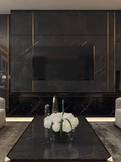 This media wall is crafted from black marble with inlaid brass details, creating a bold and luxurious focal point. The integrated fireplace and symmetrical sofa arrangement result in a balanced and powerful design statement.