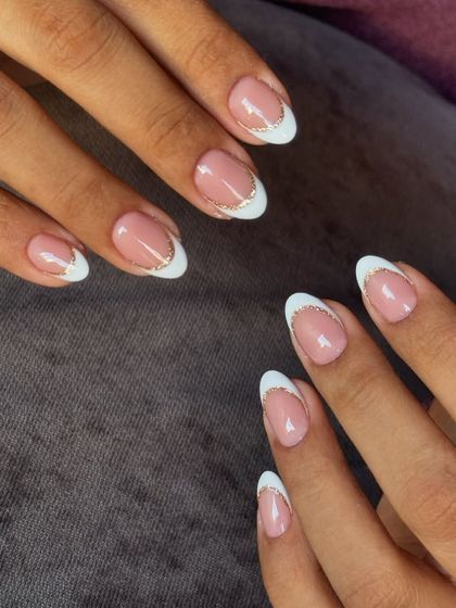 A beautiful reverse French manicure, where the glittery gold accent is placed along the cuticle for a unique and chic look.