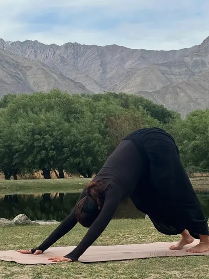 Adho Mukha Svanasana (Downward-Facing Dog) with a view of the Himalayas. This pose feels different when you're surrounded by such majesty.