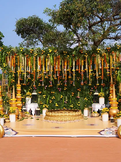 A classic Haldi ceremony setup, designed to feel both sacred and joyful. I used a lush green backdrop with hanging garlands of marigold and other flowers, a central urli for the rituals, and ornate golden swan props to create a beautiful focal point.