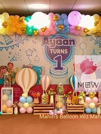 A whimsical first birthday combining a Cocomelon theme with hot-air balloon props. The hand-drawn style backdrop adds a unique, storybook feel to the celebration.